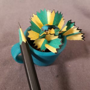 multi colored pencil shavings in a mini coffee mug