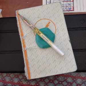 image of a beatten up notebook and a mostly used pencil resting on an eraser.